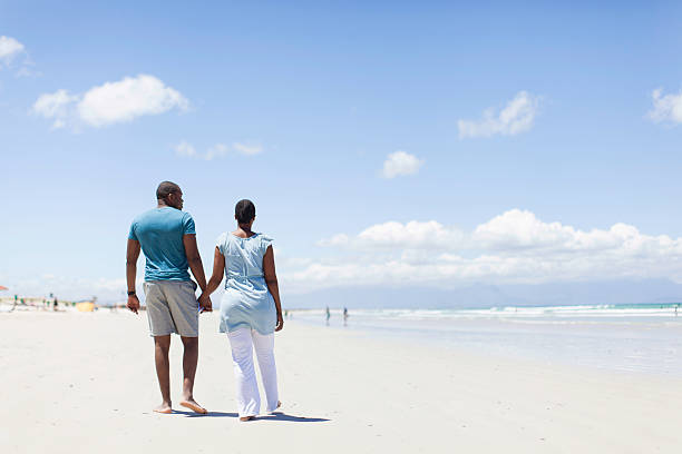 istock African couple walking on the beach 501177041