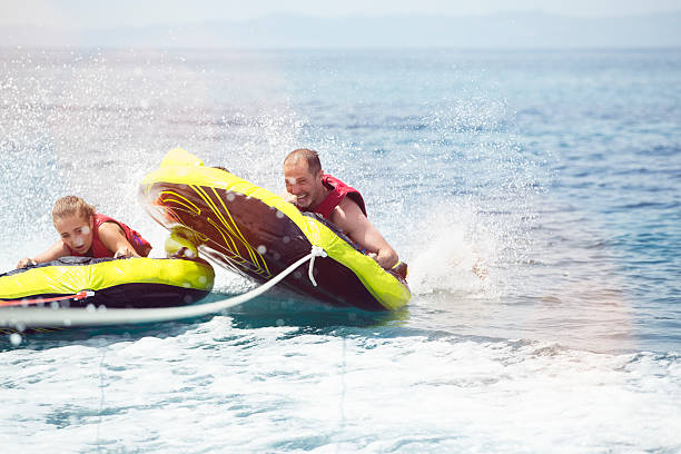 счастливый человек водные виды спорта. - water sport family inner tube sport стоковые фото и изображения
