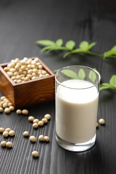 close up shot of a glass of soymilk and soybeans