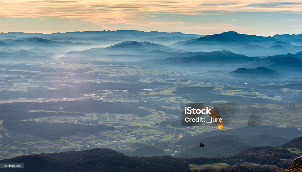 Paraglider is flying in the valley Paraglider is flying in the valley. Paragliding from the mountain with perfect view Parachute Stock Photo