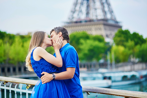 Romantic dating couple on a bridge over the Seine in Paris, Eiffel tower is in the background