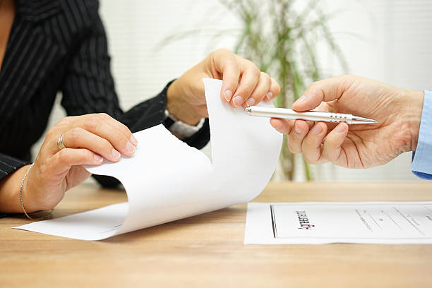 Woman tears agreement documents  in front of agent stock photo