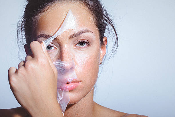Beauty portrait of a young woman applying-removing face mask Close-up beauty portrait of a beautiful, natural young woman removing face mask. Copy space has been left peeled photos stock pictures, royalty-free photos & images