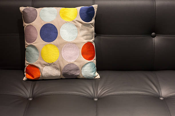 istock Colorful dotted pillow on a black leather sofa 501199932