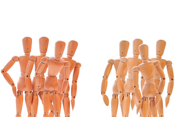 Two group of dummies Two colored group of wooden characters isolated on white two groups stock pictures, royalty-free photos & images