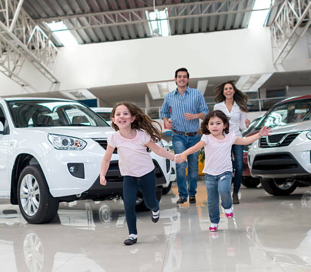 Family buying a car Very happy family buying a new car car show stock pictures, royalty-free photos & images