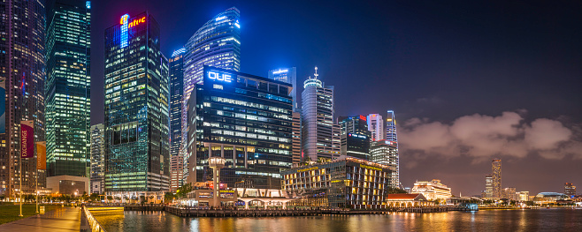 The neon lights and colourful glow of the restaurants, skyscrapers and hotels of Singapore's Central Business District reflecting in the still waters of Marina Bay. ProPhoto RGB profile for maximum color fidelity and gamut.
