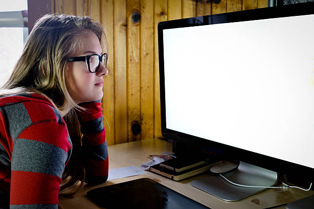 istock Young woman or teen working at a computer screen. 501222048