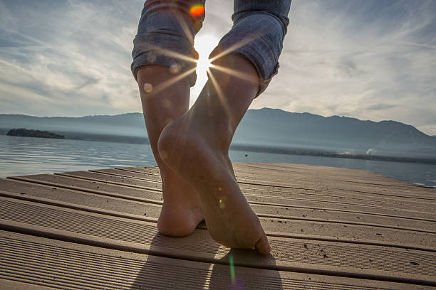 istock Woman's feet on jetty above lake at sunset 501224376