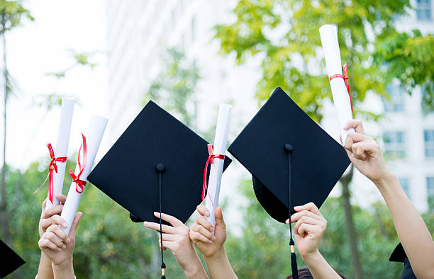 istock Graduates holding motarboards and diplomas 501230660