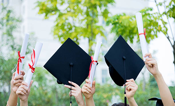 istock Graduates holding motarboards and diplomas 501230794