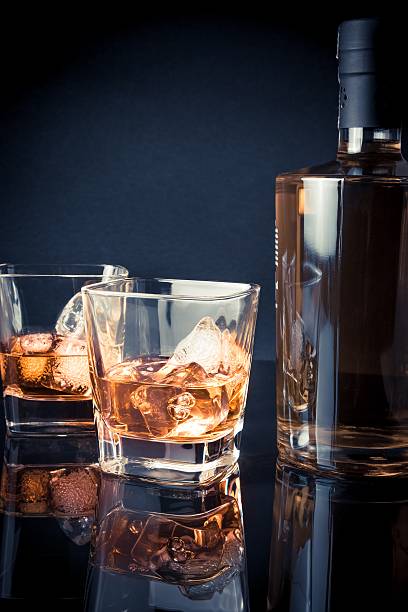istock whiskey with ice in glasses near bottle on black background 501250746