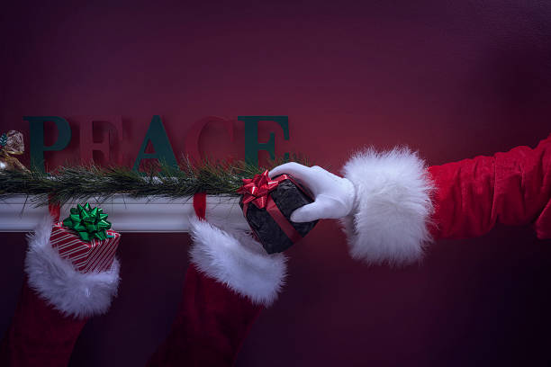 istock Santa's hand placing coal into Christmas Stockings 501251498