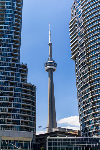 View of the CN Tower in Toronto between other buildings