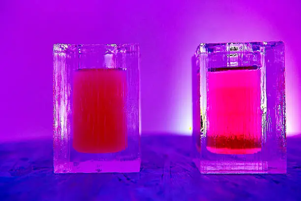 Close-up of two pink cocktails in a glass of ice at the ice bar.