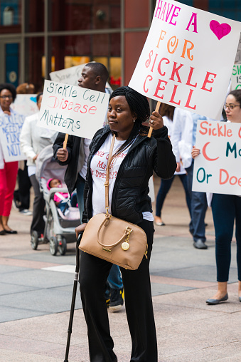 Chicago, USA - September 10, 2015: A woman protesting to raise awareness outside the James R Thompson Center in downtown for Sickle Cell funding late in the day.