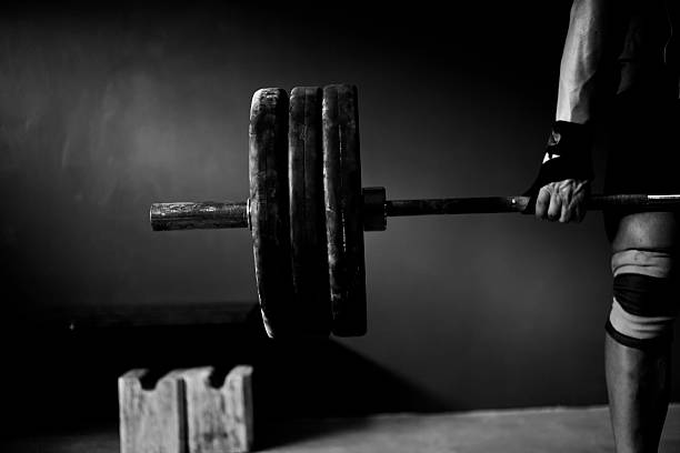 Man practising weightlifting VIII a photo of a man lifting barbell and disks powerlifting stock pictures, royalty-free photos & images