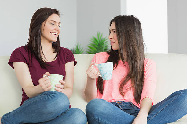 istock Two girls sitting having a conversation and drinking a beverage 501259237