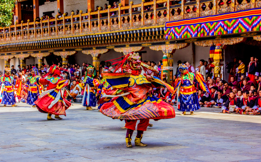 Punakha, Bhutan - March 8, 2014: masked dancers at  drupchen festival in the dzong of Punakha, Bhutan. Drupchen festival is taking place yearly in march.