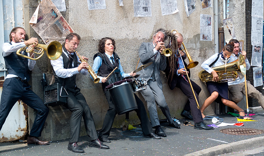 Aurillac, France - August 23, 2013: Group of musicians playing against a wall, as part of the Aurillac International Street Theater Festival, cie Rhinofanpharyngite.