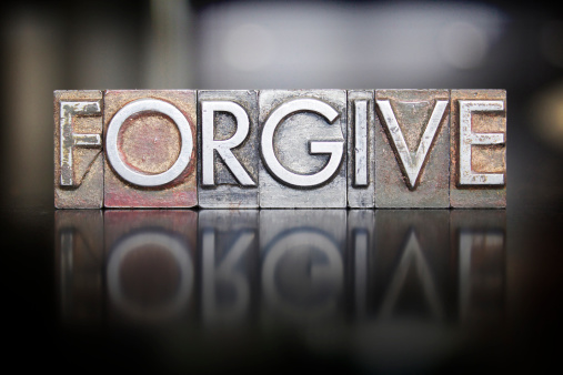 The word FORGIVE written in vintage letterpress type