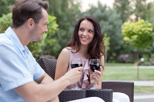 istock Loving young couple toasting red wine on chairs in park 501261965