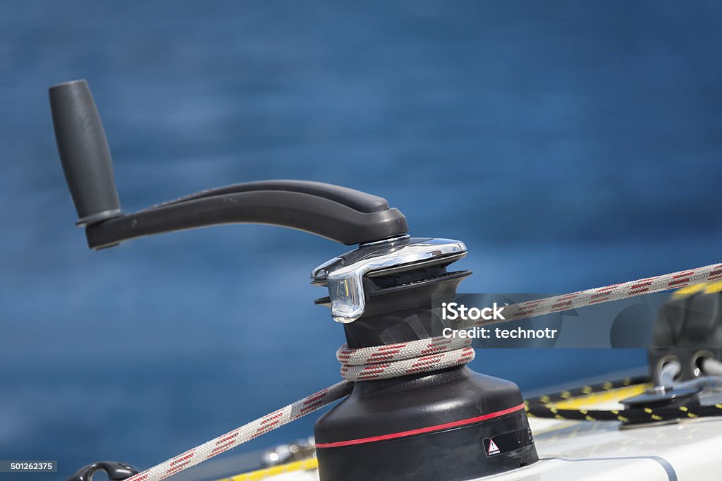 Close-up of Winch and the Rope on Sailing Boat Side view of winch against the sea, shallow depth of field Blue Stock Photo