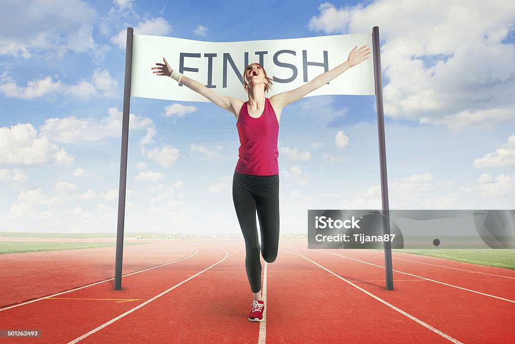 Woman crossing the finish line Finish Line Stock Photo