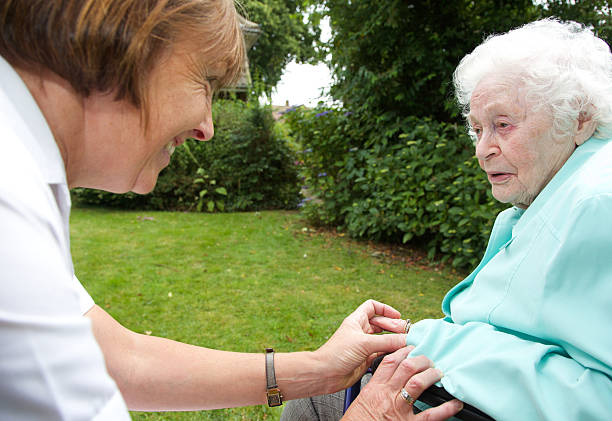 istock Nurse careworker caring for an elderly client in a garden 501263405