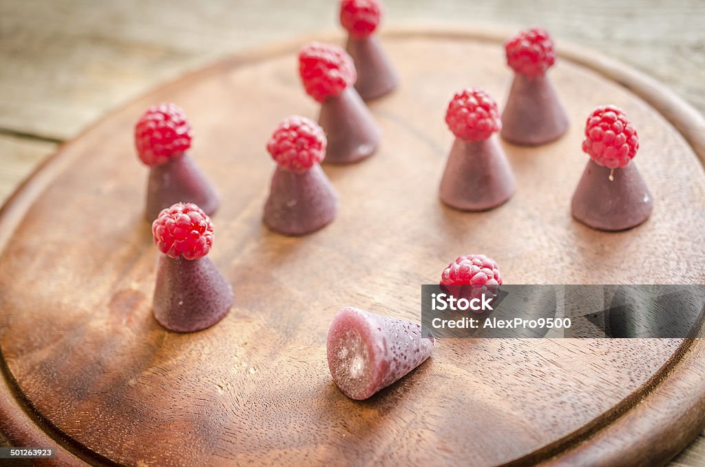 Cuberdons with fresh raspberries on the wooden board Arabic Style Stock Photo