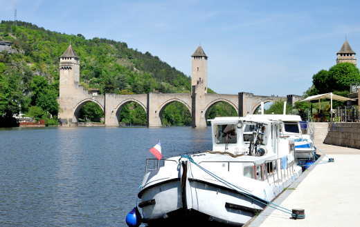 The XIV century pont Valentré in Cahors in Quercy, Dordogne.At foreground two  boats