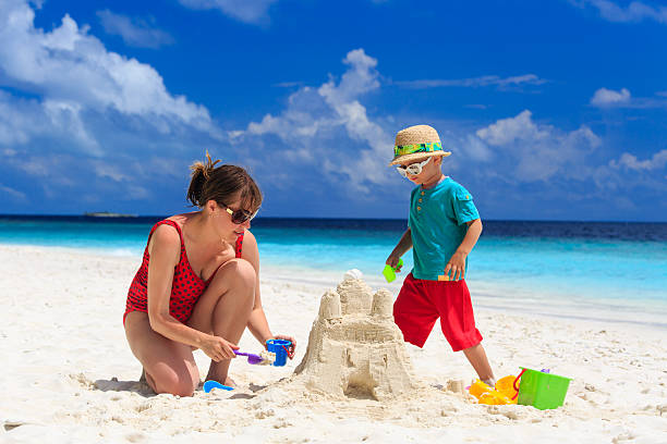 istock mother and son building castle on the beach 501265387