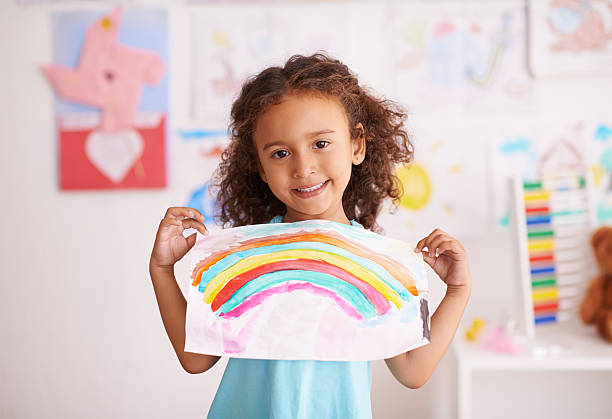 Showing off her creative work Shot of a little girl holding up a picture she painted of a rainbowhttp://195.154.178.81/DATA/i_collage/pi/shoots/783539.jpg spectrum photos stock pictures, royalty-free photos & images