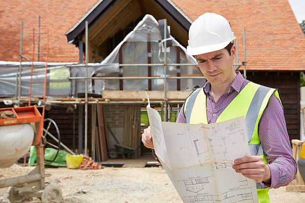 istock Architect On Building Site Looking At House Plans 501276123