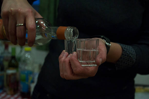 versare in un bicchiere di bere alcol - vodka hard liquor bottle palinka foto e immagini stock