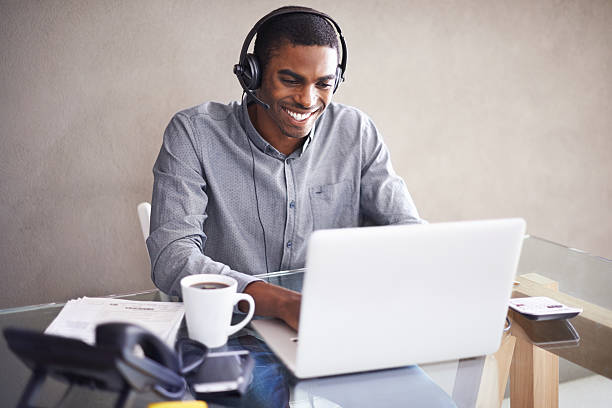 glücklich in seinem home arbeitsplatz - working at home headset telecommuting computer stock-fotos und bilder