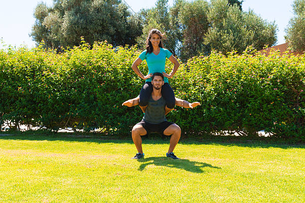 athlétique jeune couple de faire des exercices de remise en forme dans le parc - mascular photos et images de collection