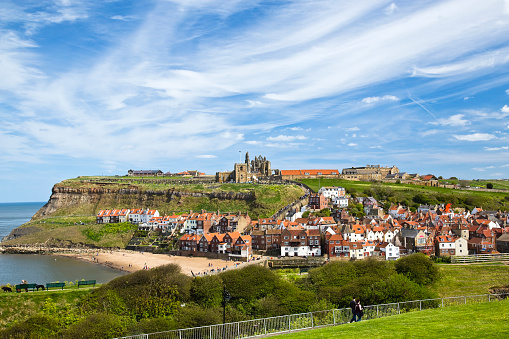 View of Church and Abbey ruins on top of cliffs above Whitby Town