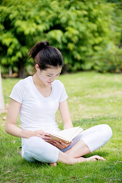 istock Young woman reading a book in park 501286050