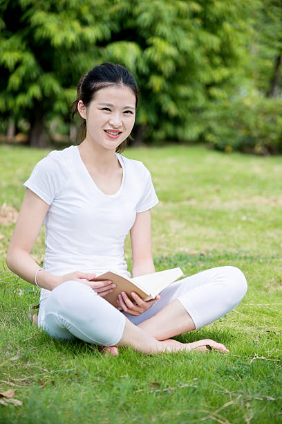 istock Young woman reading a book in park 501286250