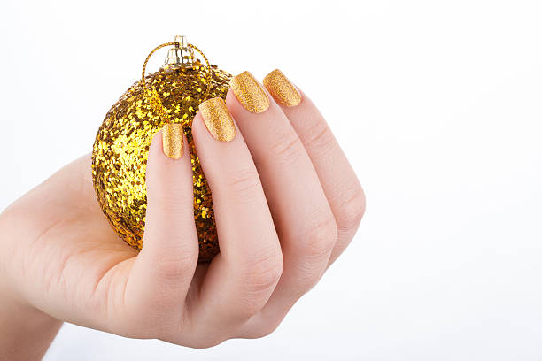 Beautiful golden manicure. Beautiful well-groomed golden nails close up. yellow nail polish stock pictures, royalty-free photos & images