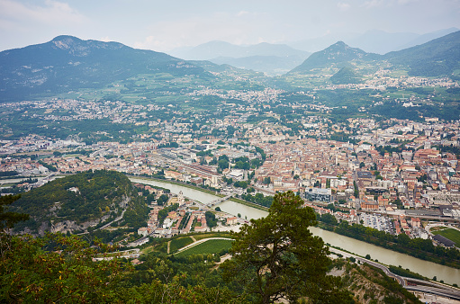 Trento is located in a valley in North Italy. View from the mountain across the river. Trento is an old city with castle and city wall around the initial settlement. Today a modern big city in the trentino area. The mountains are part of the mountain range The Dolomites