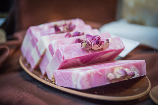 Bars of natural handmade soap made of fresh ingredients, (rose, olive). Pink roses on the top. Nikon D800, full frame, XXXL.