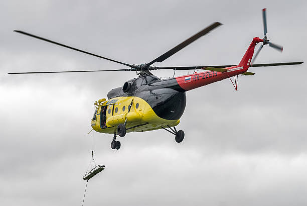 Descent of empty stretcher from MI-8 helicopter Tyumen, Russia - August 23, 2008: On visit at UTair airshow in Plehanovo heliport. Descent of empty stretcher from MI-8 helicopter by rope shooting guard stock pictures, royalty-free photos & images