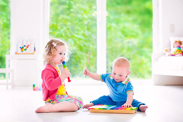 istock Kids playing music with xylophone in white room 501292083