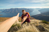 Young man hiking pulls out hand to get assistance