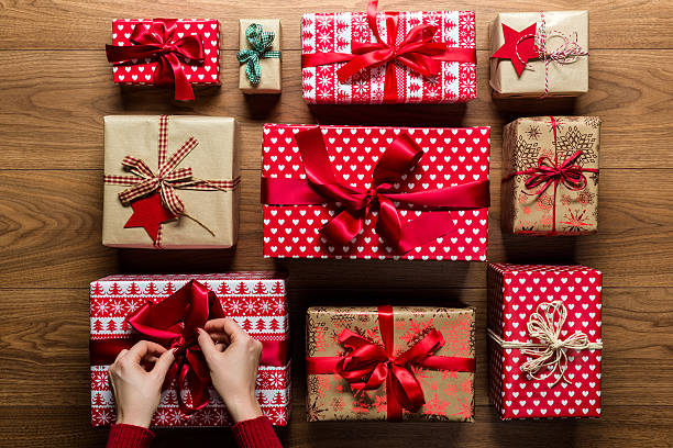 istock Woman fixing a bow on christmas presents, view from above 501292884