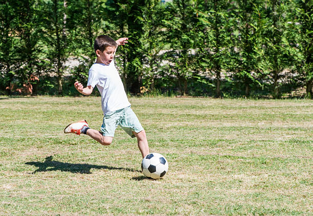 istock Child playing football in a stadium 501294185