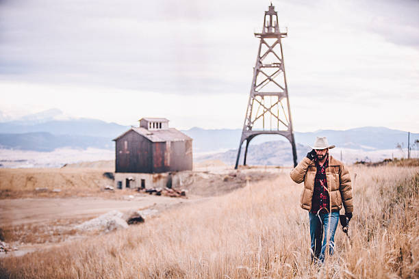 istock Western man talking on phone and walking through hay field 501294517