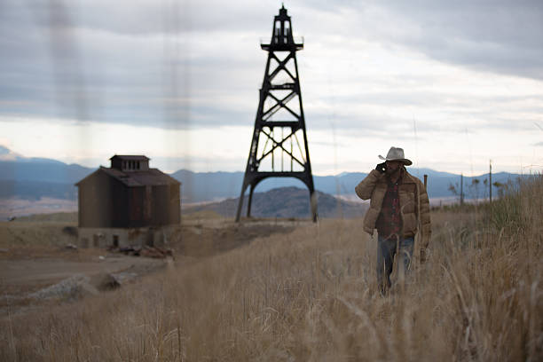 istock Western man talking on phone and walking through field 501294565